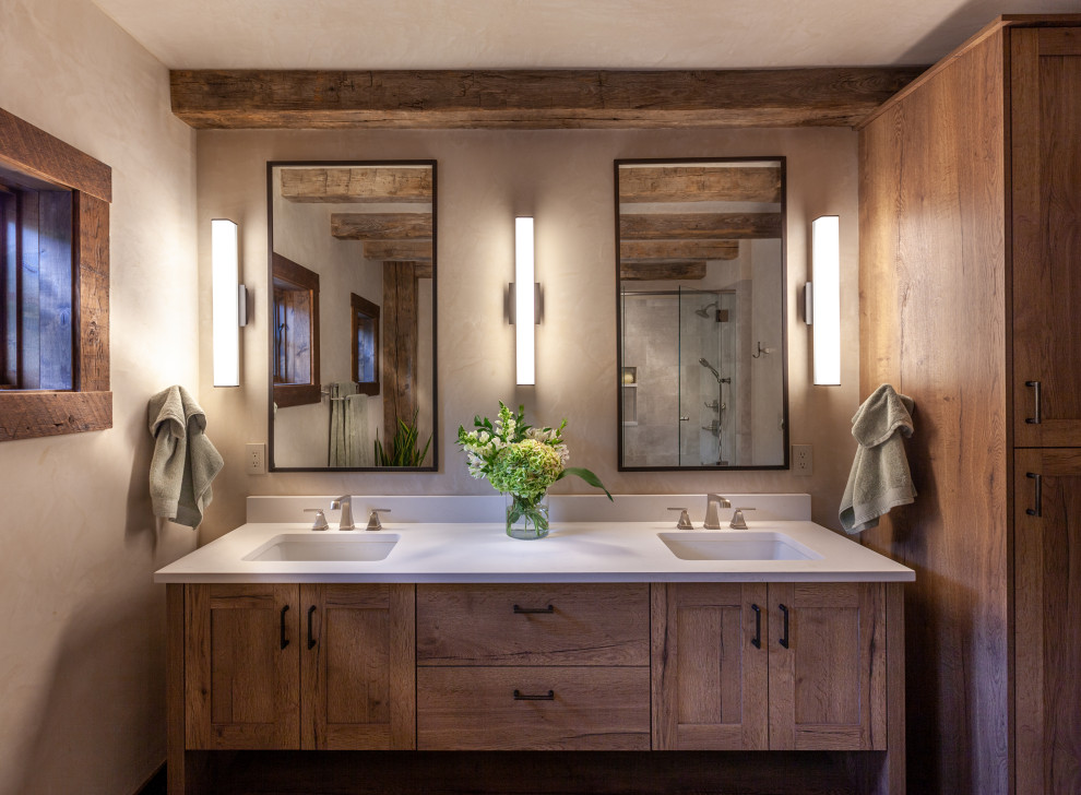This is an example of a country bathroom in Denver with shaker cabinets, medium wood cabinets, beige walls, an undermount sink, white benchtops, a double vanity and a freestanding vanity.