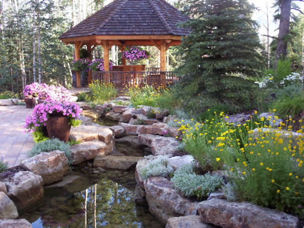 Inspiration for a huge rustic full sun backyard stone water fountain landscape in Denver for spring.