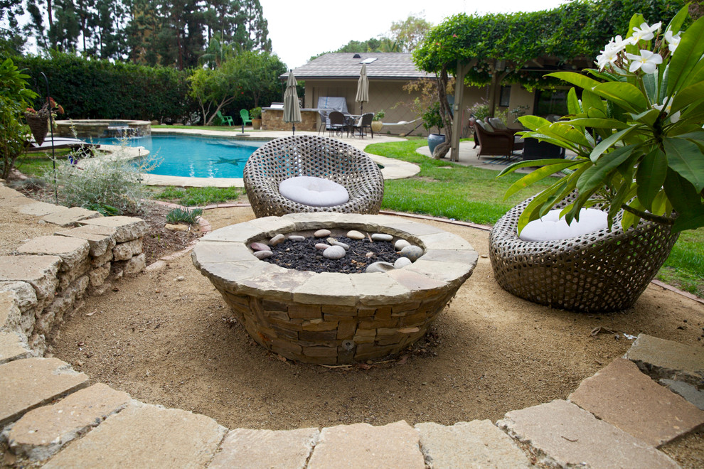 This is an example of a mid-sized contemporary backyard full sun garden in Orange County with a fire feature and gravel.