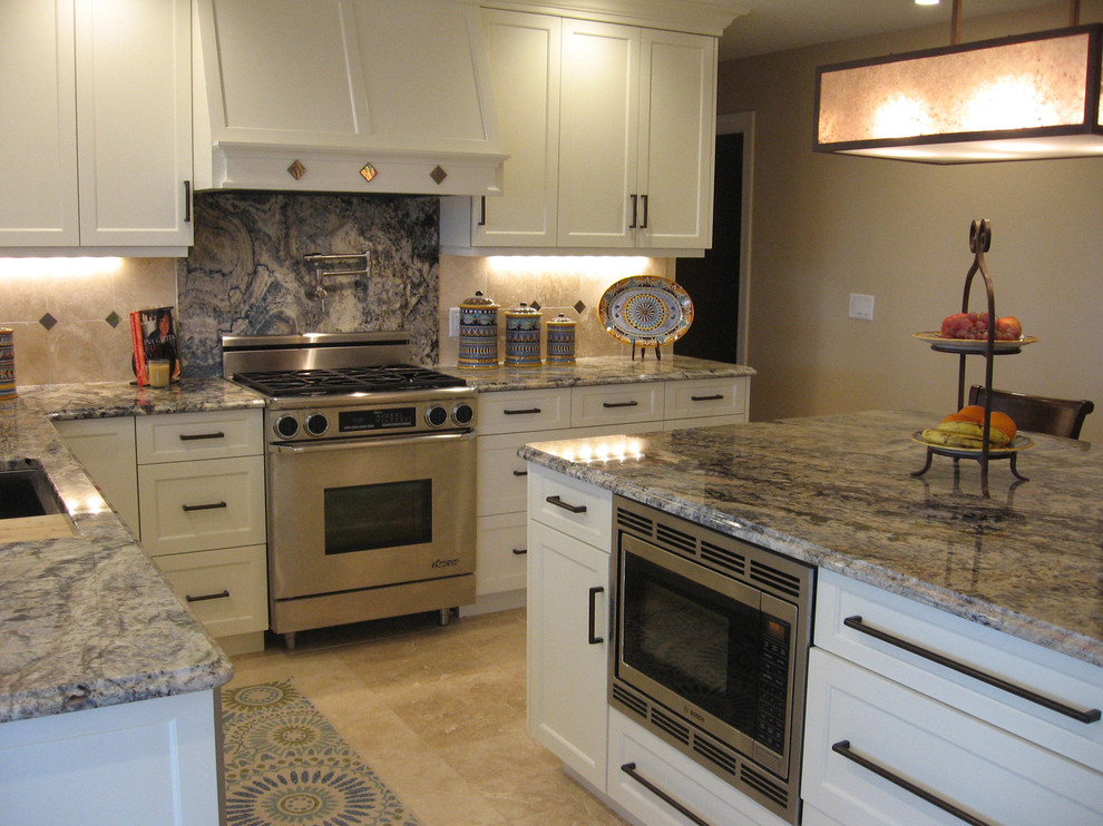 Transitional l-shaped eat-in kitchen in Cedar Rapids with an undermount sink, recessed-panel cabinets, white cabinets, granite benchtops, beige splashback, stone tile splashback, stainless steel appliances, travertine floors, with island and blue benchtop.