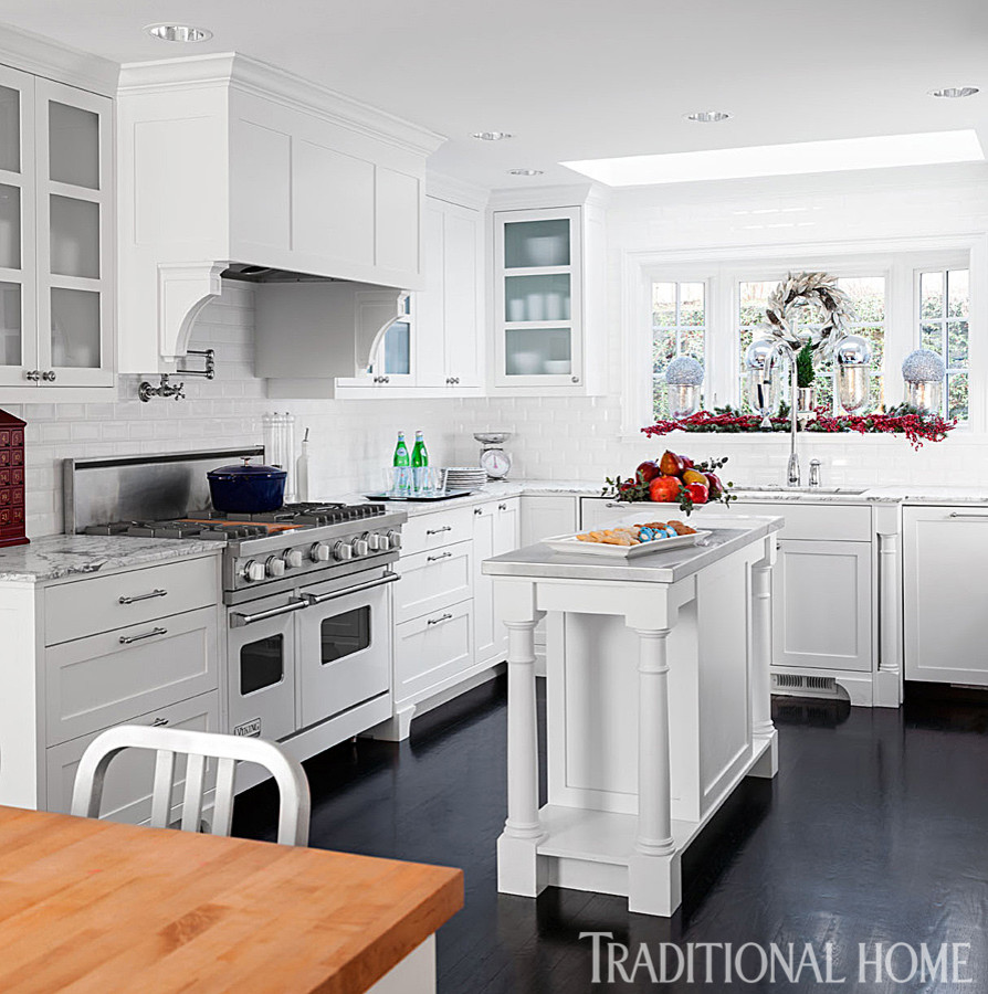 Inspiration for a mid-sized eclectic u-shaped eat-in kitchen in Seattle with a farmhouse sink, shaker cabinets, white cabinets, marble benchtops, white splashback, subway tile splashback, white appliances, dark hardwood floors and multiple islands.