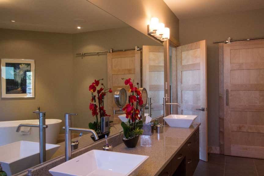 This is an example of a large transitional master bathroom in Albuquerque with dark wood cabinets, a freestanding tub, beige walls, a vessel sink and engineered quartz benchtops.