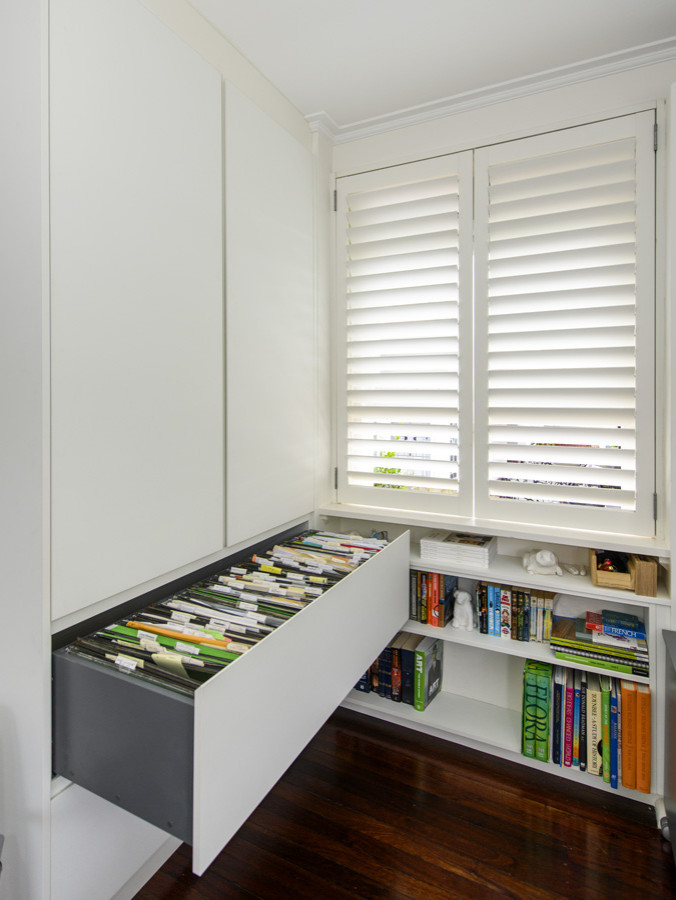 Mid-sized eclectic built-in desk dark wood floor study room photo in Sydney with white walls