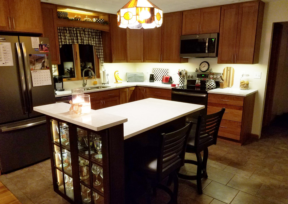 Mid-sized transitional l-shaped ceramic tile and yellow floor eat-in kitchen photo with an undermount sink, shaker cabinets, medium tone wood cabinets, quartz countertops, stainless steel appliances, an island and white countertops