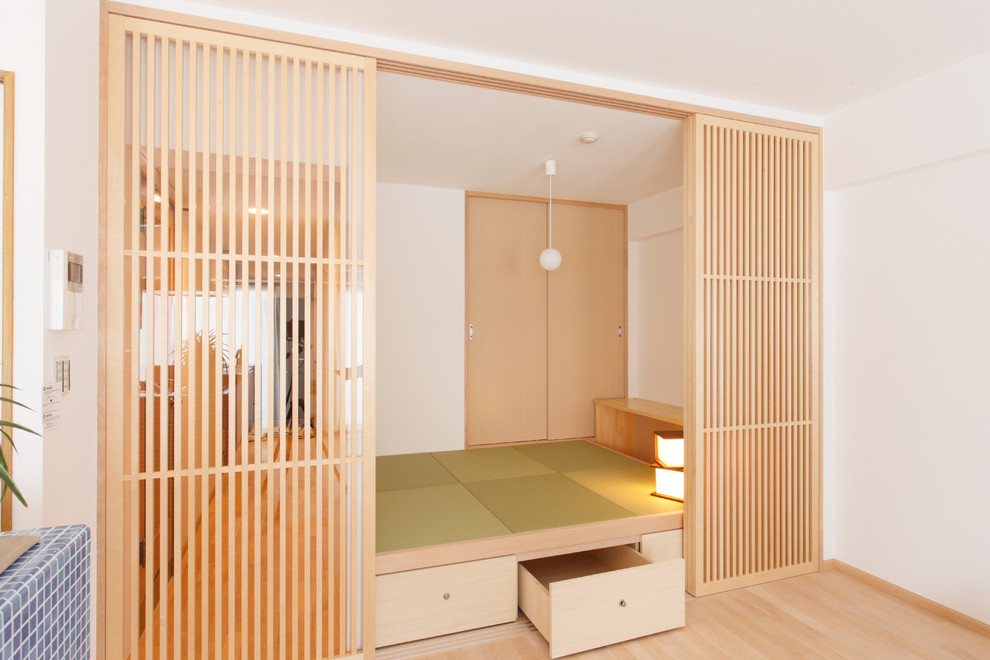 Photo of an enclosed family room in Other with white walls, tatami floors and green floor.