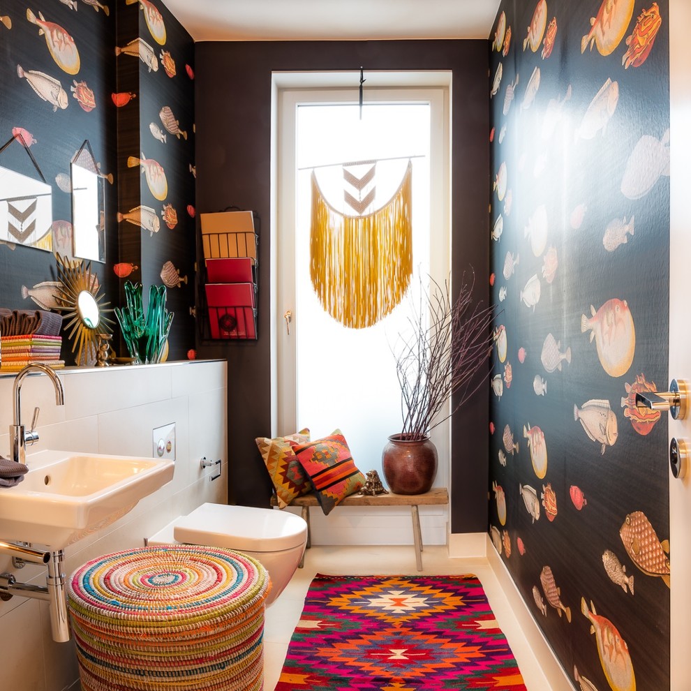 Mid-sized eclectic powder room in Hamburg with black walls, limestone floors, a wall-mount sink, solid surface benchtops, beige floor, a wall-mount toilet and porcelain tile.