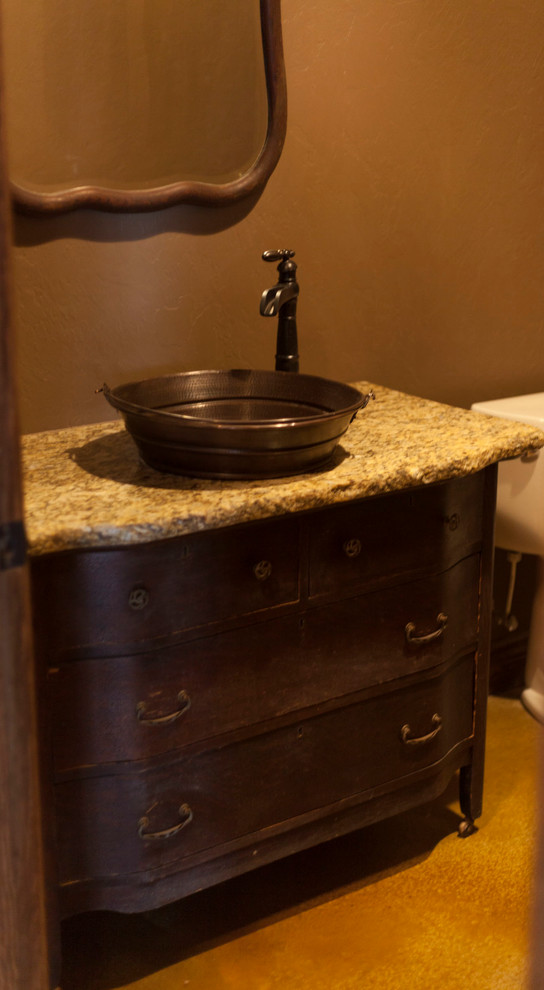 Small country 3/4 bathroom in Oklahoma City with a vessel sink, granite benchtops, furniture-like cabinets, dark wood cabinets, a two-piece toilet, multi-coloured tile, stone tile, beige walls and linoleum floors.