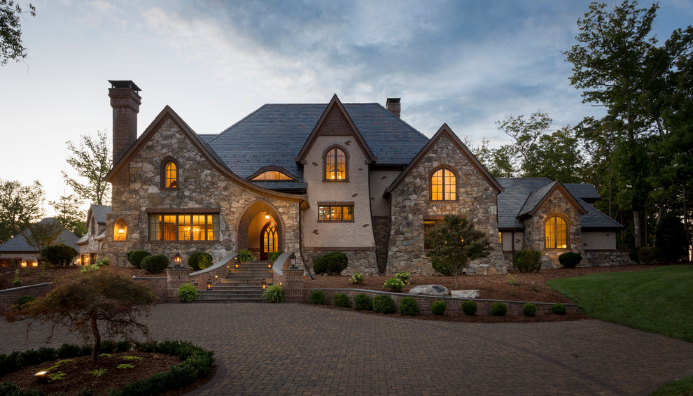 Design ideas for an expansive arts and crafts two-storey grey exterior in Other with stone veneer.