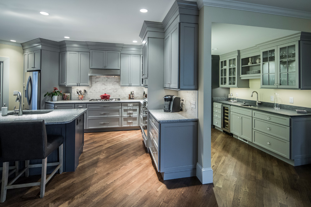 Inspiration for a large transitional single-wall dark wood floor eat-in kitchen remodel in Boston with an undermount sink, flat-panel cabinets, gray cabinets, granite countertops, white backsplash, ceramic backsplash, stainless steel appliances and an island
