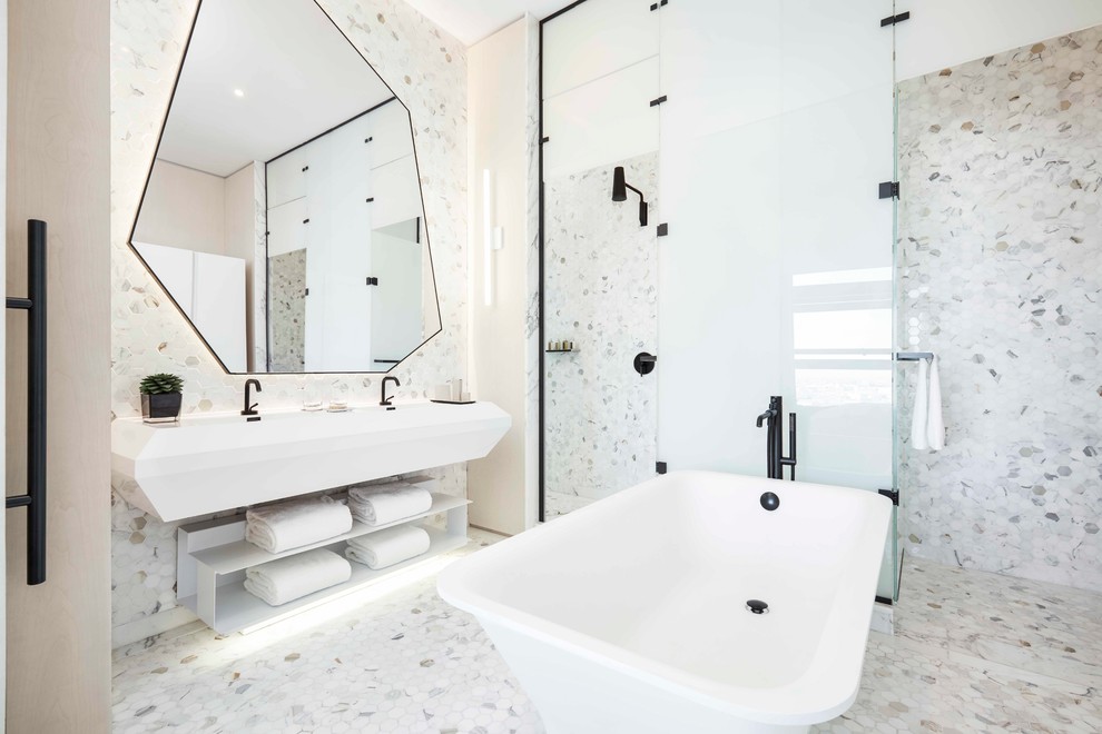 Design ideas for a contemporary master bathroom in New York with a freestanding tub, stone tile, white walls, porcelain floors, white floor, a hinged shower door, open cabinets, white cabinets, solid surface benchtops, white benchtops, a corner shower, white tile and an integrated sink.