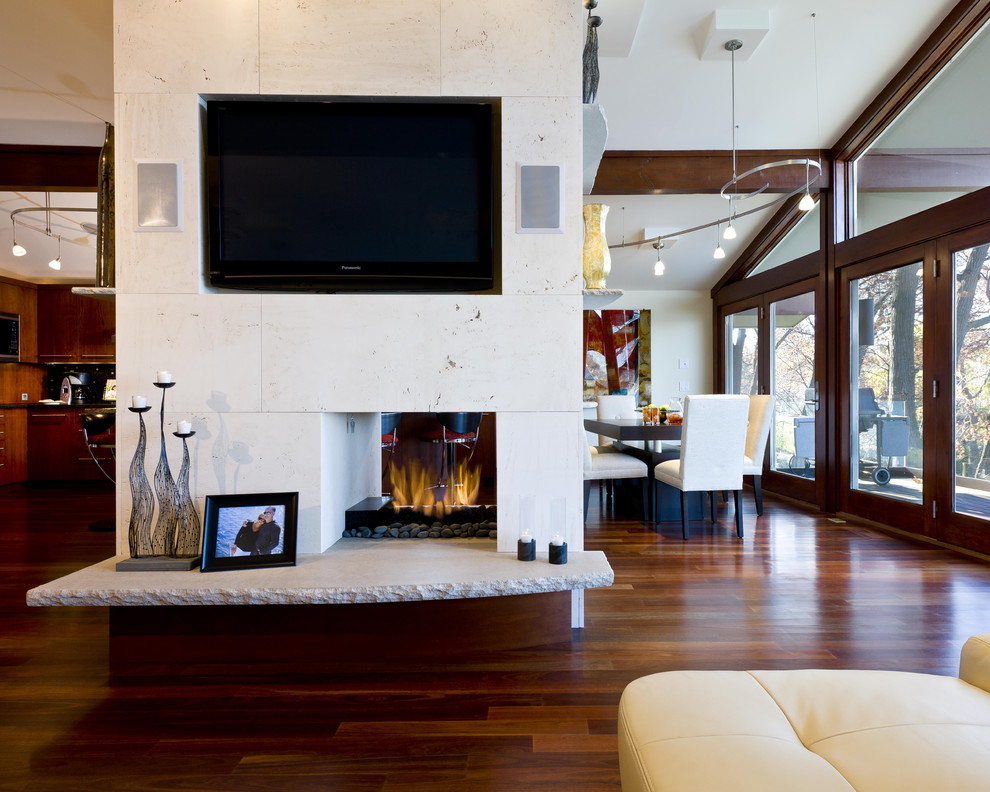 This is an example of a contemporary living room in Minneapolis with a two-sided fireplace and a wall-mounted tv.