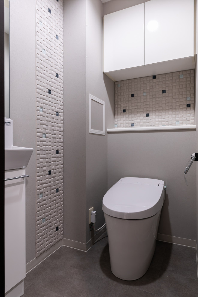 Kleine Moderne Gästetoilette mit Toilette mit Aufsatzspülkasten, schwarz-weißen Fliesen, Mosaikfliesen, grauer Wandfarbe, Vinylboden, Wandwaschbecken, grauem Boden, Tapetendecke und Tapetenwänden in Tokio