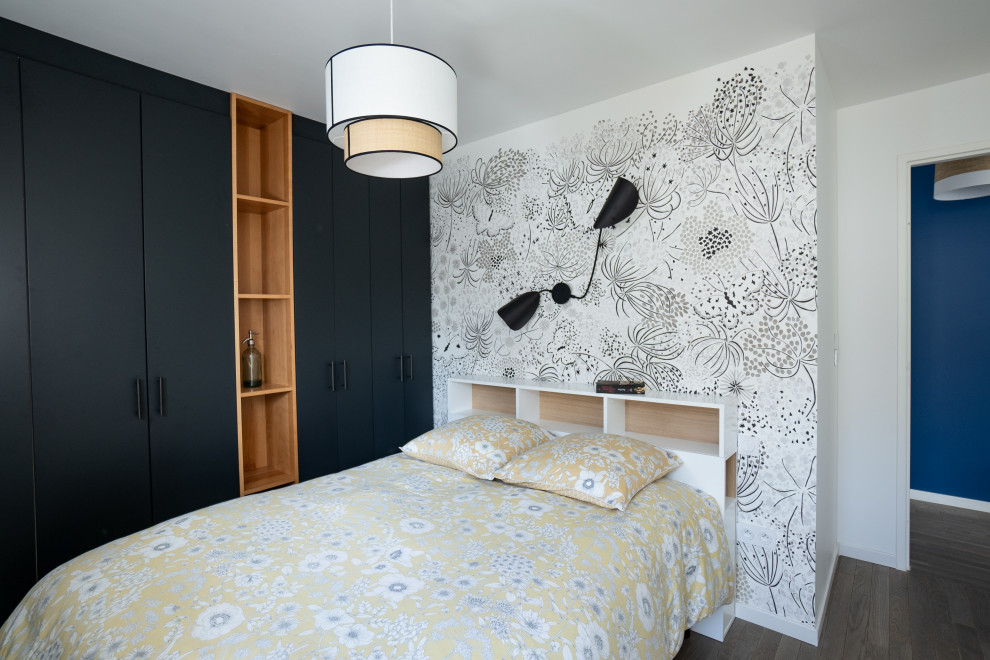 Idée de décoration pour une grande chambre design avec du papier peint et dressing.