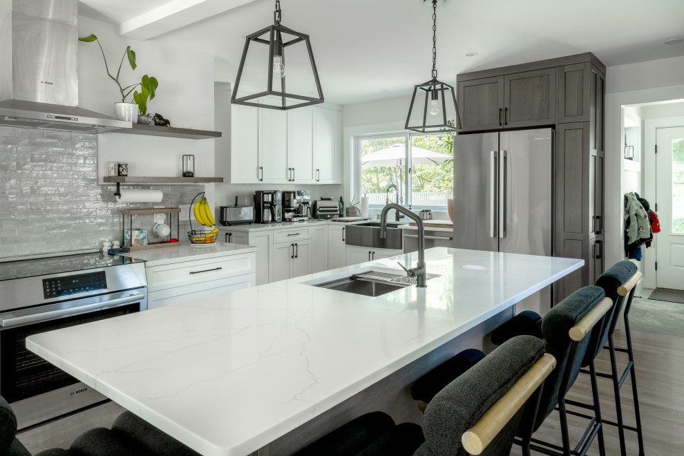 Inspiration for a large contemporary l-shaped medium tone wood floor eat-in kitchen remodel in Boston with a drop-in sink, shaker cabinets, gray cabinets, quartz countertops, gray backsplash, cement tile backsplash, stainless steel appliances, an island and white countertops