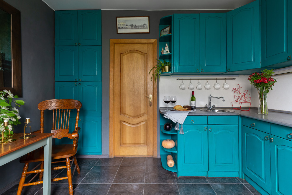 Mid-sized eclectic l-shaped eat-in kitchen in Saint Petersburg with raised-panel cabinets, turquoise cabinets, white splashback, ceramic floors, no island, grey floor and grey benchtop.