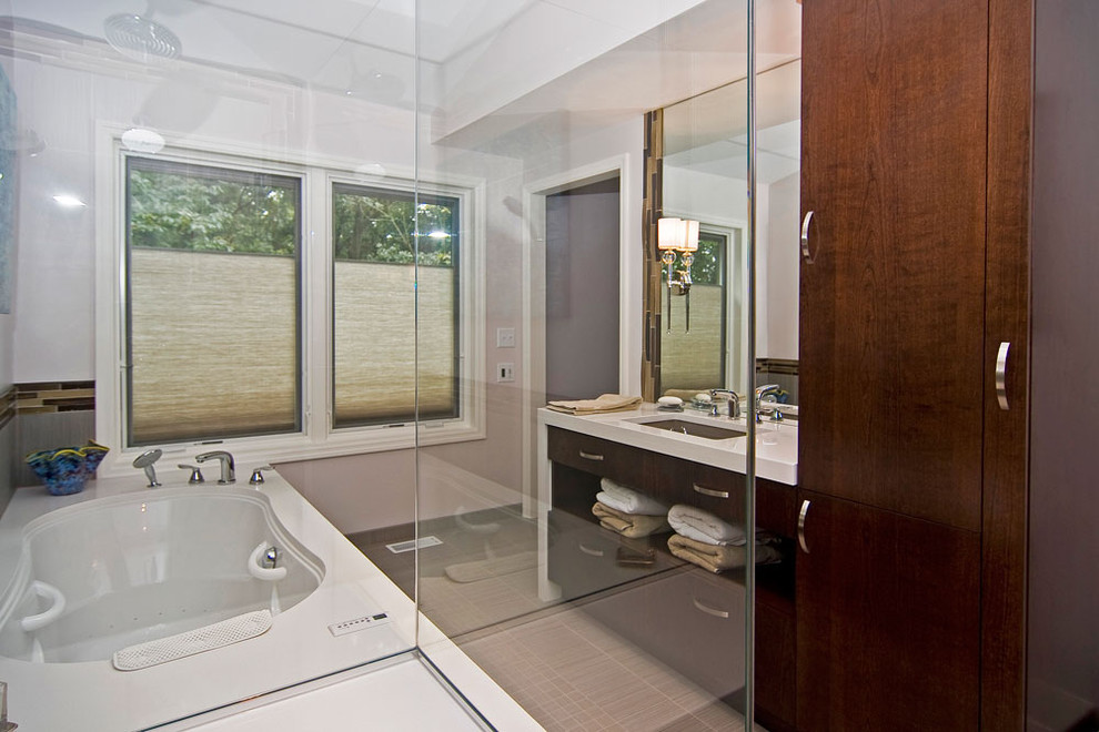 Inspiration for a mid-sized modern master bathroom in St Louis with flat-panel cabinets, dark wood cabinets, a drop-in tub, a shower/bathtub combo, a two-piece toilet, gray tile, porcelain tile, white walls, porcelain floors, an undermount sink, quartzite benchtops, beige floor and a hinged shower door.