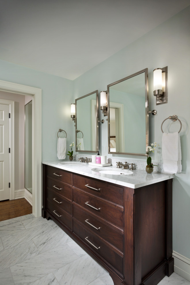 Inspiration for a mid-sized traditional master bathroom in New York with shaker cabinets, dark wood cabinets, a drop-in tub, blue walls, porcelain floors, an undermount sink, granite benchtops, grey floor, multi-coloured benchtops, a double vanity and a built-in vanity.