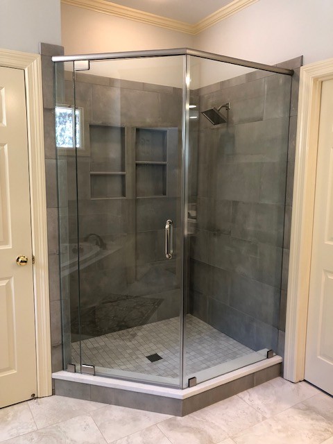 Corner bathtub - mid-sized transitional gray tile porcelain tile corner bathtub idea with shaker cabinets, dark wood cabinets, a two-piece toilet, an undermount sink, quartzite countertops and a hinged shower door