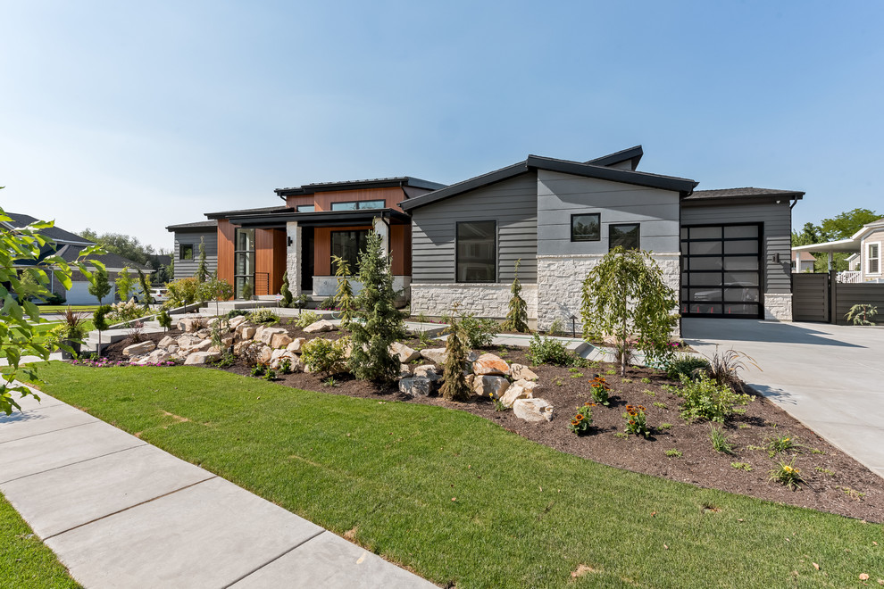 Large contemporary one-storey grey house exterior in Salt Lake City with mixed siding, a gable roof and a shingle roof.