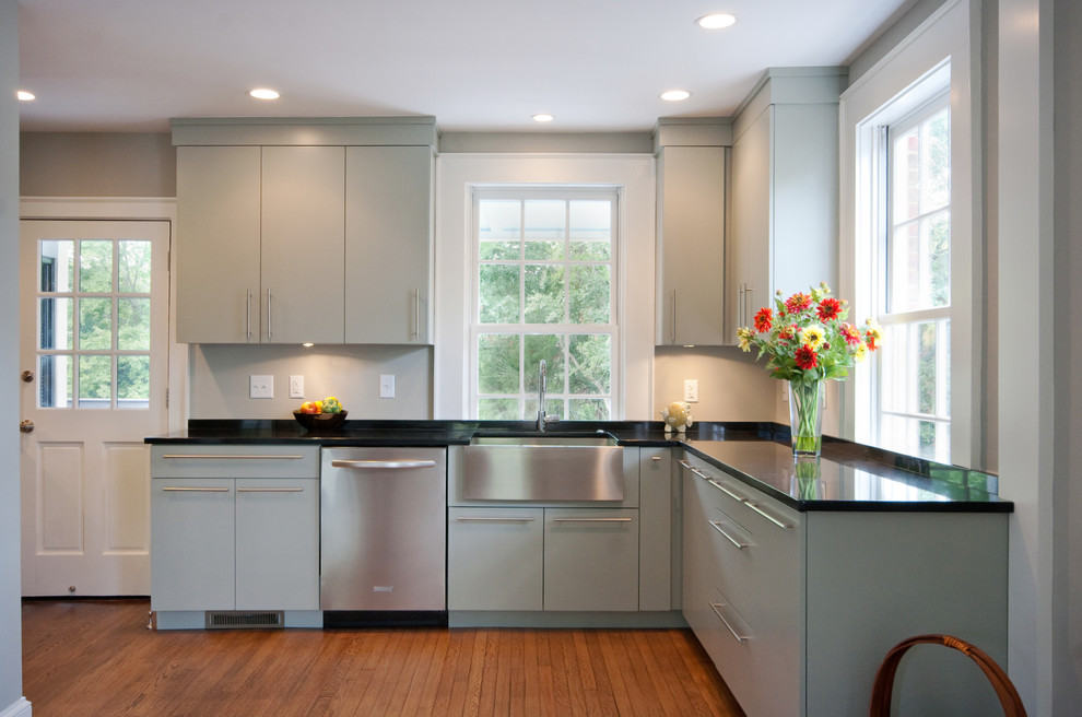 Photo of a traditional kitchen in Charleston with a farmhouse sink, stainless steel appliances, flat-panel cabinets, quartz benchtops and grey cabinets.