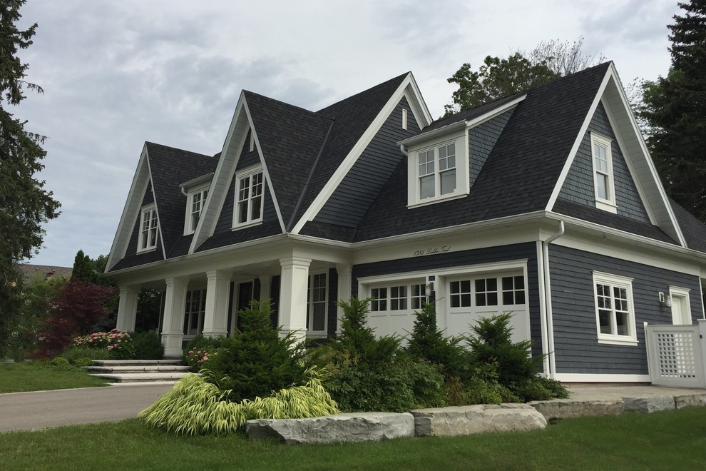 Inspiration for a large beach style two-storey grey house exterior in Toronto with wood siding, a gable roof and a shingle roof.