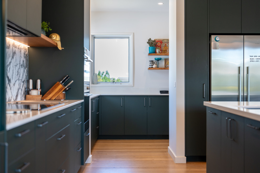 Design ideas for a medium sized contemporary kitchen in Melbourne with flat-panel cabinets, green cabinets, stone slab splashback and an island.