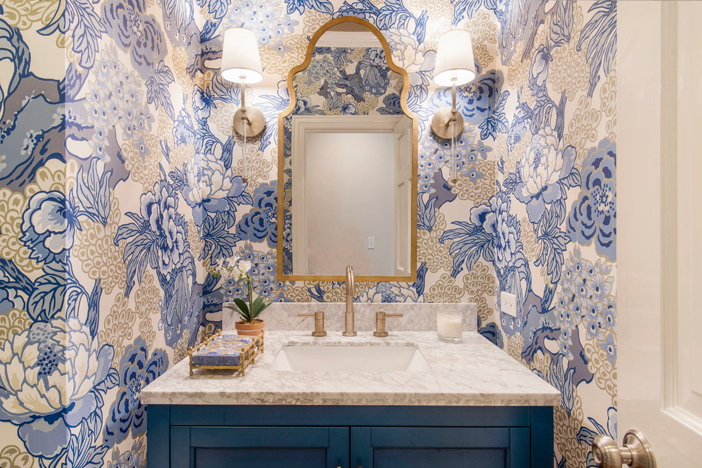 Example of a small transitional medium tone wood floor and brown floor powder room design in Chicago with shaker cabinets, blue cabinets, blue walls, an undermount sink, quartz countertops and white countertops