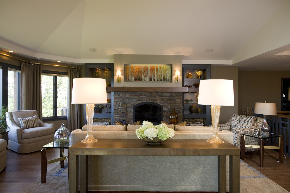 This is an example of a traditional living room in Other with brown walls, a standard fireplace and a stone fireplace surround.