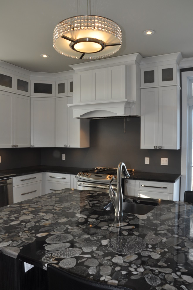 Large transitional l-shaped ceramic tile enclosed kitchen photo in Ottawa with an undermount sink, shaker cabinets, white cabinets, granite countertops, stainless steel appliances and an island