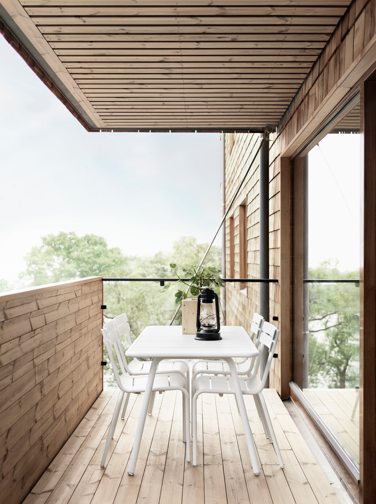 Inspiration for a mid-sized scandinavian balcony in Stockholm with a roof extension.