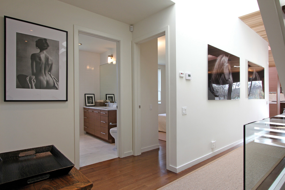 Inspiration for a mid-sized contemporary hallway in New York with white walls and medium hardwood floors.