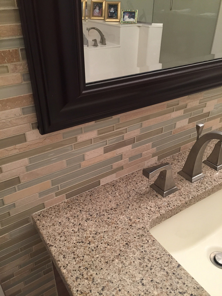 Corner shower - large transitional master beige tile and ceramic tile ceramic tile and beige floor corner shower idea with raised-panel cabinets, dark wood cabinets, a two-piece toilet, beige walls, an undermount sink, a hinged shower door, quartzite countertops and brown countertops