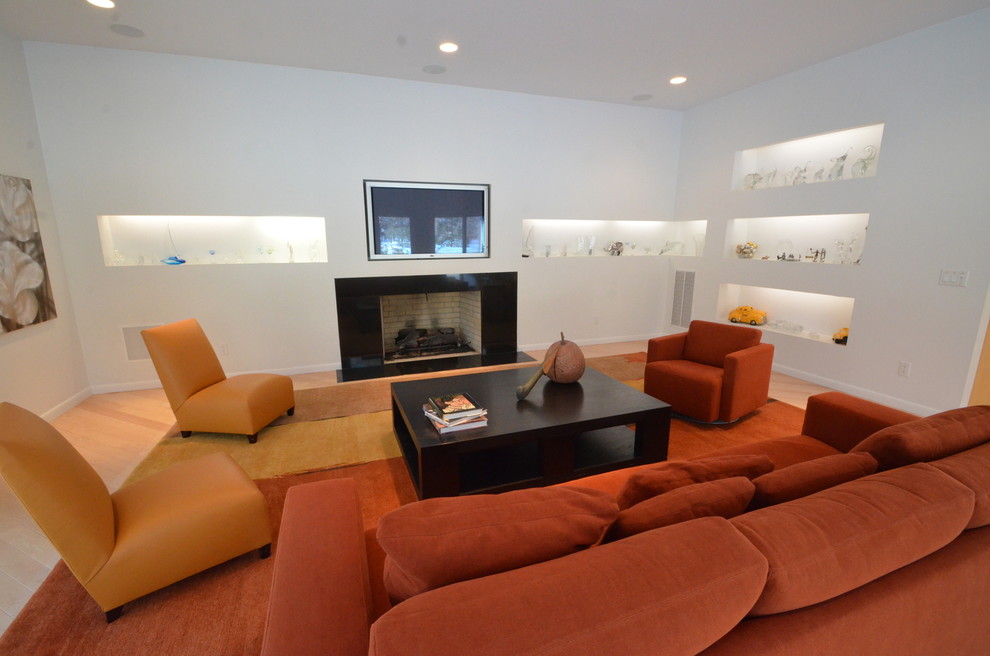 Mid-sized modern enclosed family room in New York with white walls, carpet, a standard fireplace, a tile fireplace surround, a wall-mounted tv and beige floor.