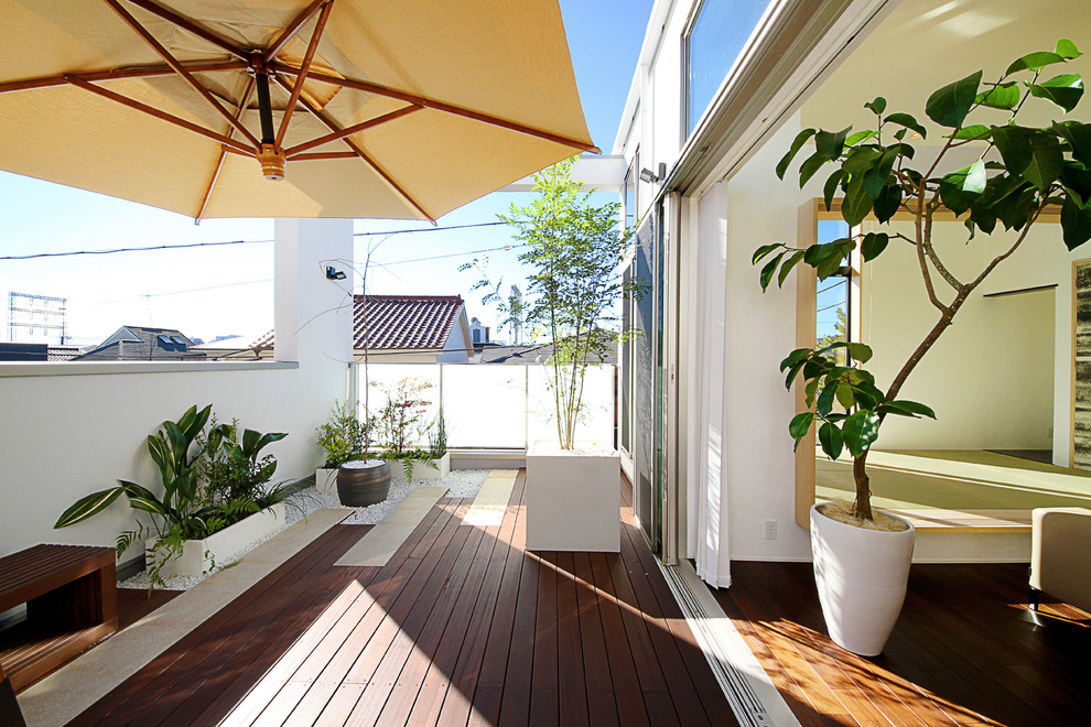 Inspiration for a mid-sized asian balcony in Tokyo with a container garden and an awning.