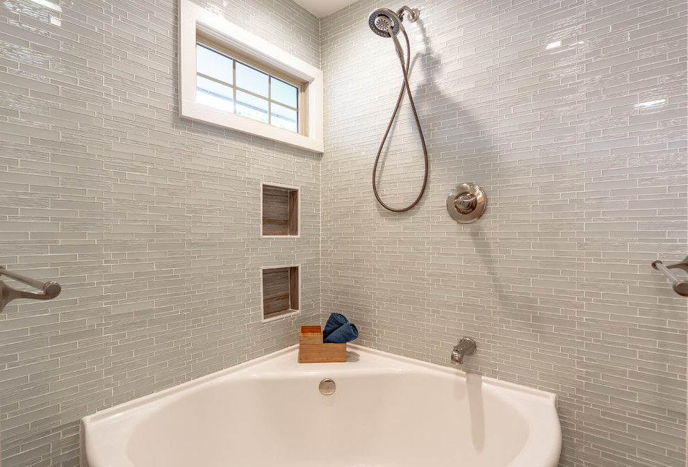 Large transitional master bathroom in Kansas City with glass-front cabinets, dark wood cabinets, a corner tub, a shower/bathtub combo, a two-piece toilet, gray tile, glass tile, beige walls, porcelain floors, an integrated sink, glass benchtops, beige floor, a shower curtain and blue benchtops.