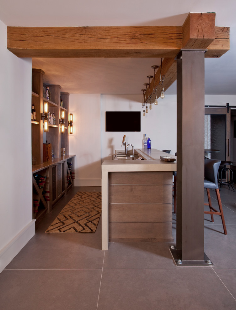 This is an example of an industrial seated home bar in Atlanta with open cabinets, concrete benchtops and porcelain floors.