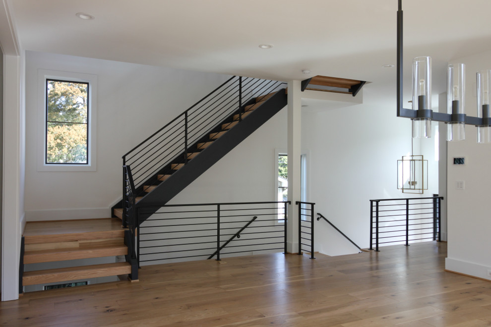 Photo of a mid-sized contemporary wood straight staircase in DC Metro with metal railing.