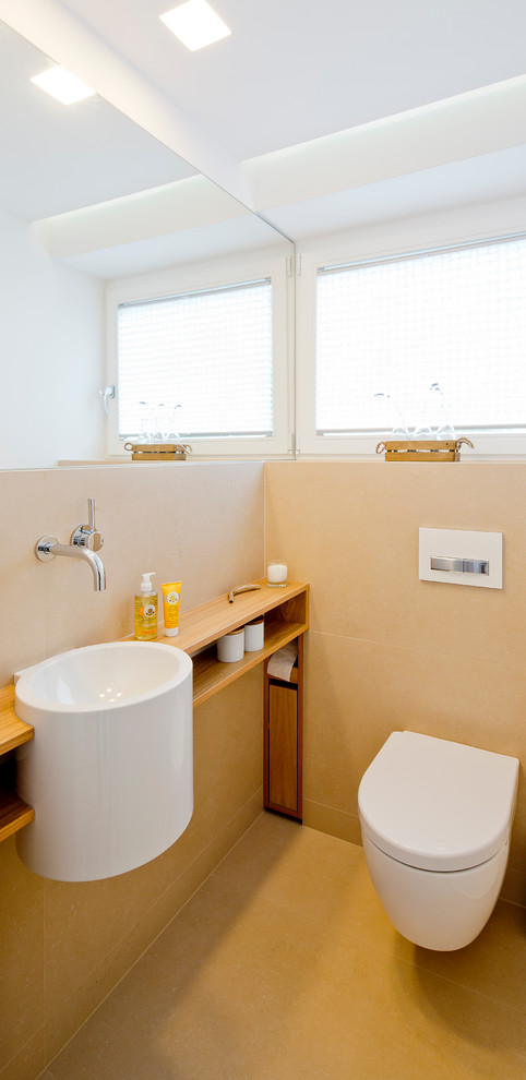 Photo of a small contemporary bathroom in Dusseldorf with open cabinets, medium wood cabinets, a wall-mount toilet, beige tile, ceramic tile, white walls, a wall-mount sink and wood benchtops.