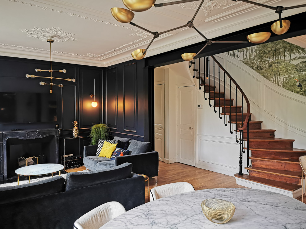 Inspiration for a mid-sized transitional open concept living room in Paris with black walls, medium hardwood floors, a standard fireplace, a metal fireplace surround, a wall-mounted tv and brown floor.