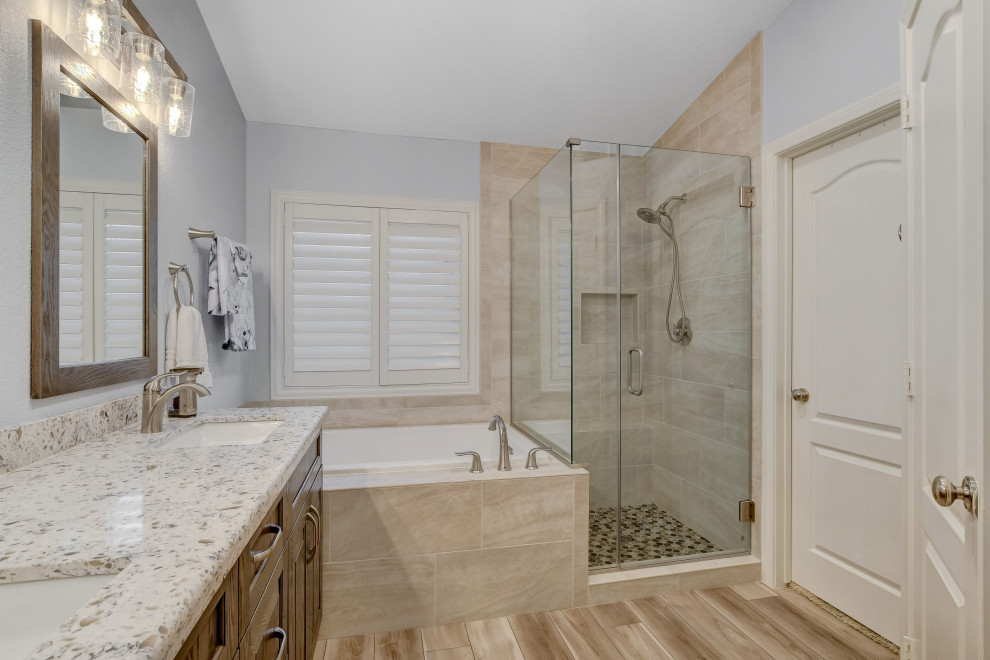 Photo of a large contemporary master bathroom in Las Vegas with a corner tub, a corner shower, a one-piece toilet, beige tile, stone tile, white walls, wood-look tile, granite benchtops, brown floor, a hinged shower door, white benchtops, a double vanity and a built-in vanity.