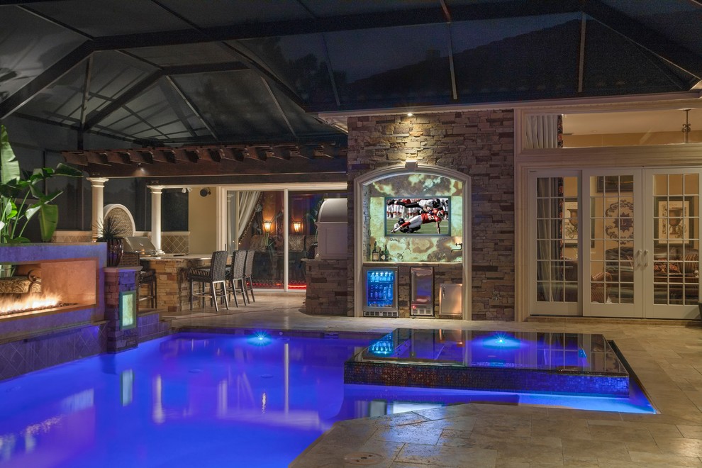 Photo of a small transitional backyard custom-shaped pool in Tampa with natural stone pavers and a hot tub.