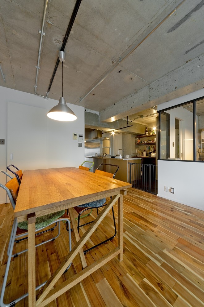 Design ideas for an industrial open plan dining in Osaka with white walls, medium hardwood floors and brown floor.