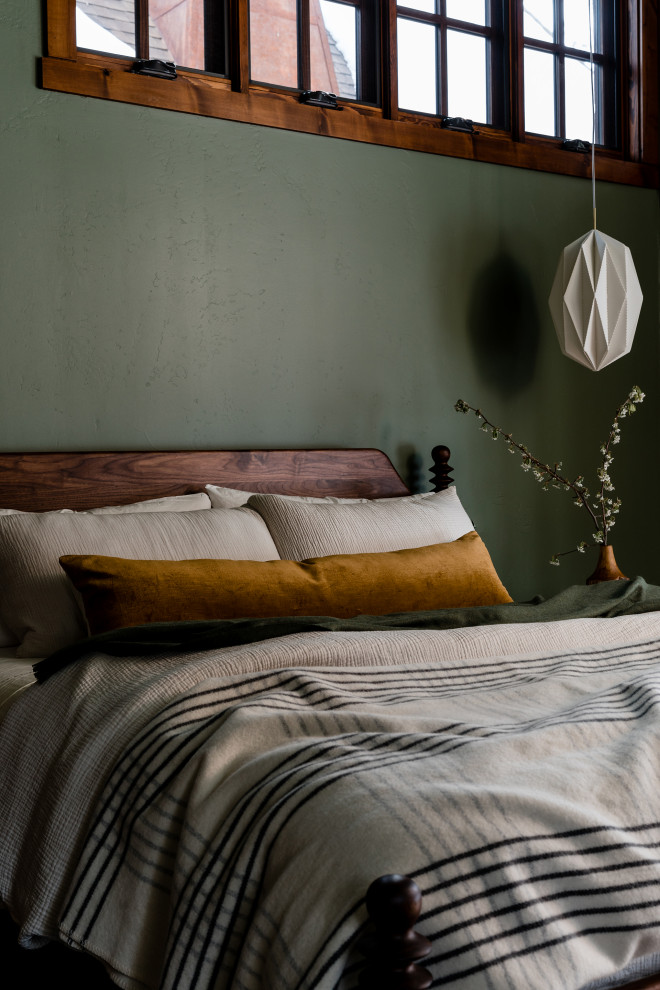 Modelo de dormitorio principal bohemio grande con paredes verdes, suelo de madera en tonos medios y suelo multicolor