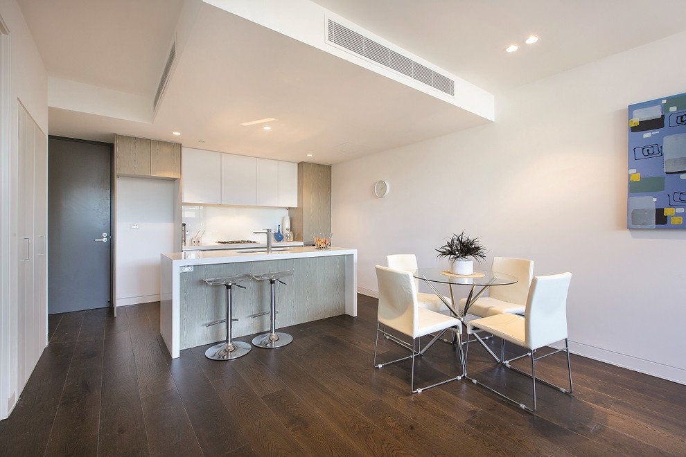 Mid-sized contemporary open plan dining in Melbourne with white walls and dark hardwood floors.