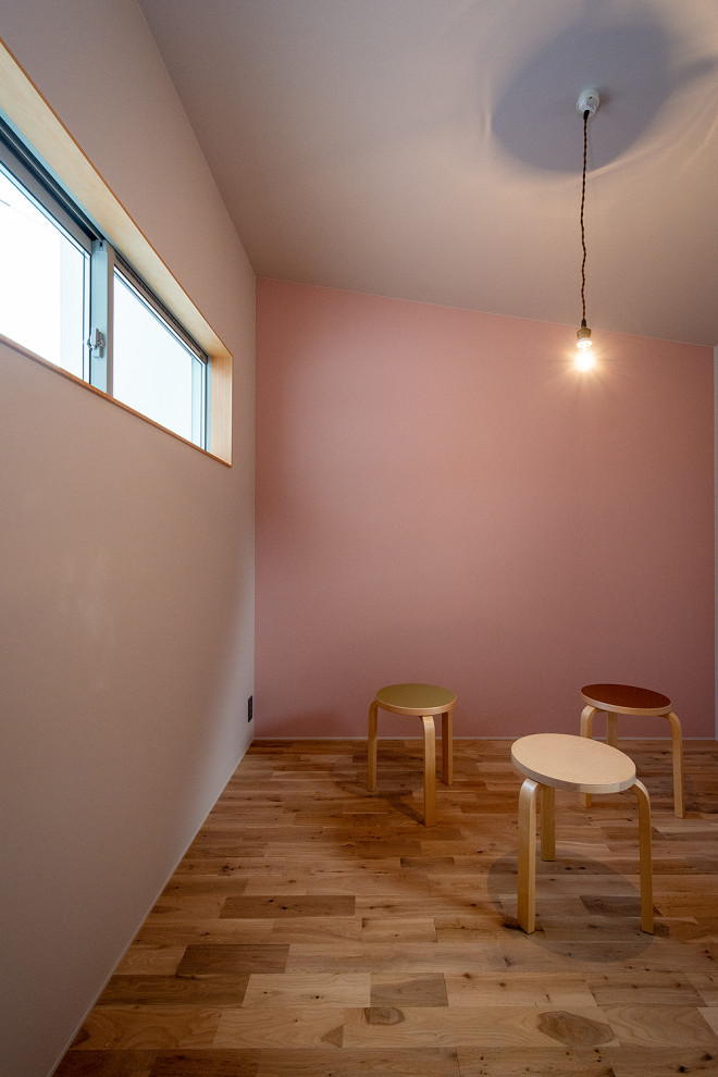 Foto på ett litet skandinaviskt flickrum kombinerat med sovrum och för 4-10-åringar, med rosa väggar, mellanmörkt trägolv och beiget golv