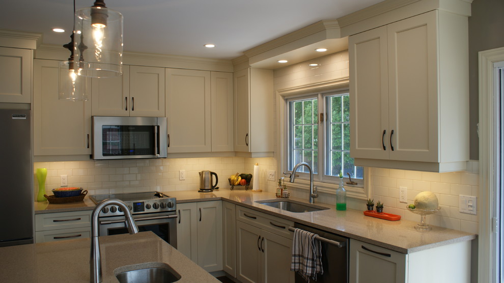 Example of a large transitional l-shaped eat-in kitchen design in Toronto with an undermount sink, shaker cabinets, white cabinets, quartz countertops, white backsplash, subway tile backsplash, stainless steel appliances and an island