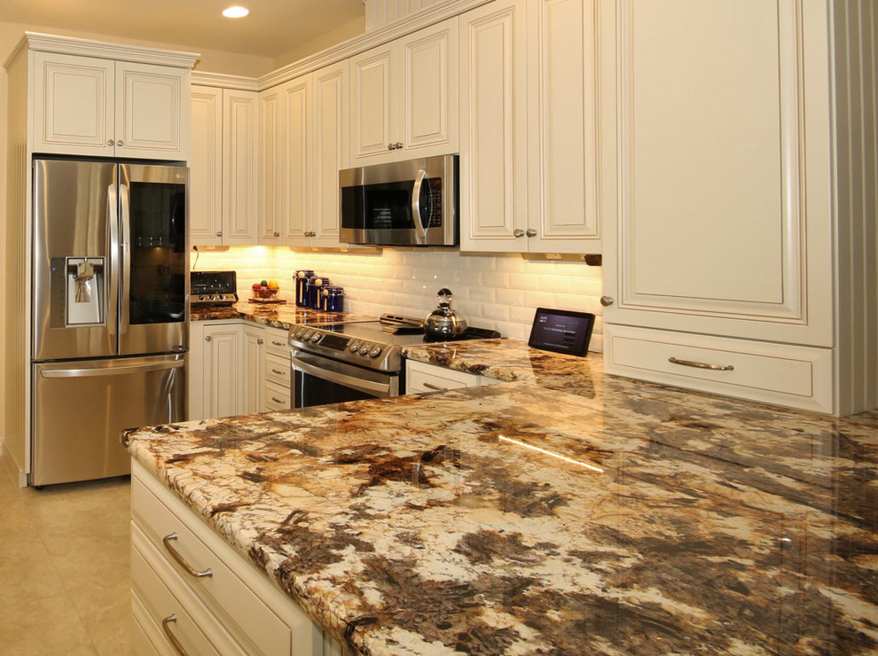Open concept kitchen - small u-shaped travertine floor and beige floor open concept kitchen idea in Phoenix with an undermount sink, raised-panel cabinets, distressed cabinets, marble countertops, white backsplash, porcelain backsplash, stainless steel appliances, no island and multicolored countertops