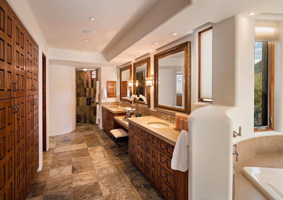 This is an example of a master bathroom in Phoenix with medium wood cabinets, a drop-in tub, a curbless shower, white walls, an undermount sink, brown floor, an open shower and recessed-panel cabinets.