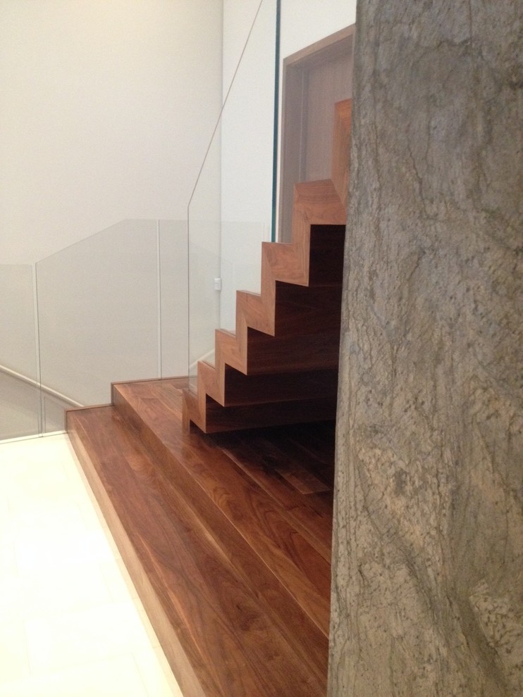 Large contemporary wood floating staircase in Los Angeles with wood risers.