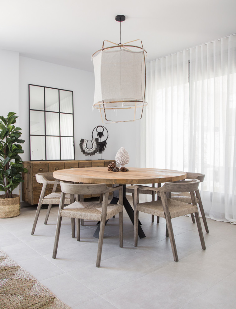 Photo of a mid-sized beach style dining room in Other with white walls and grey floor.